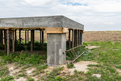 Old barn on field against sky