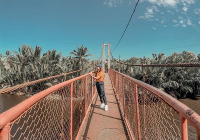 Full length of woman standing on footbridge