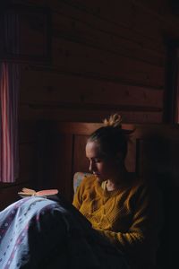 Young woman reading book at home