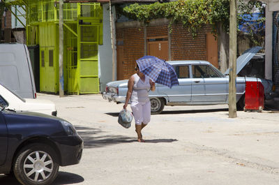 Rear view of man walking on road