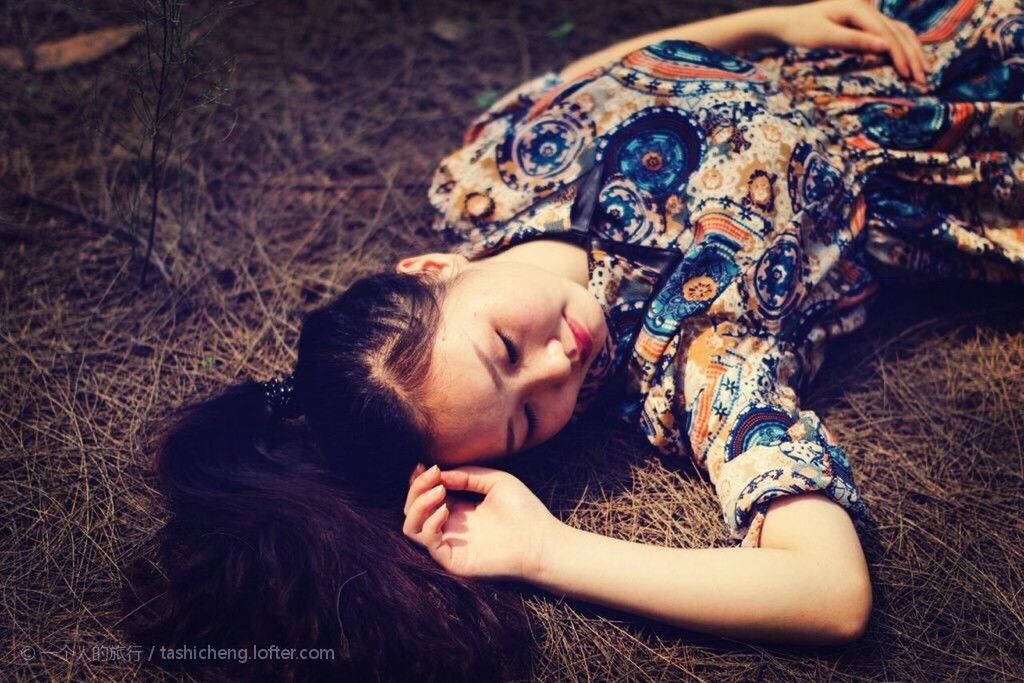 YOUNG WOMAN LYING ON GRASS