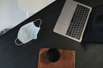 Protective mask and laptop keyboard on desk