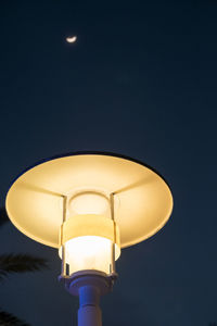 Low angle view of lamp lit up at night