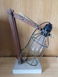 Close-up of electric lamp hanging on wooden floor