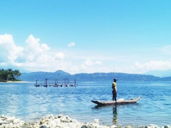 Man standing on lake against sky