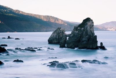 Scenic view of rocks in sea against sky