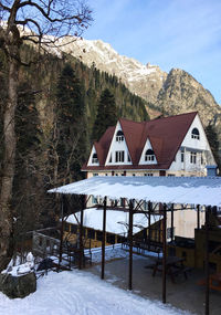 Houses on snow covered mountain against sky