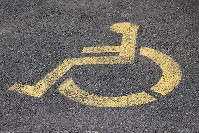 High angle view of yellow disabled sign on street