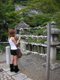 Rear view of woman standing against waterfall