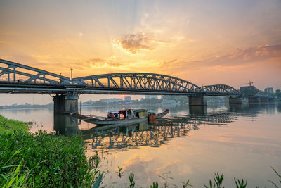 Bridge over river against sky during sunset