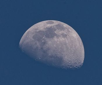 Low angle view of moon against clear blue sky