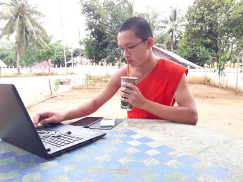 Man using mobile phone while sitting on table