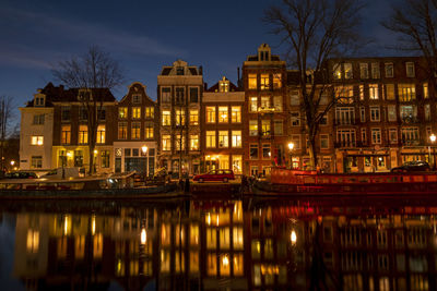 Reflection of illuminated buildings in river at night