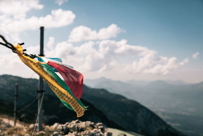 Multi colored flag on mountain against sky