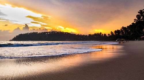 Scenic view of beach against sky during sunset