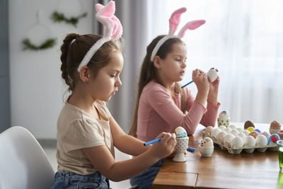 Sisters decorating eater eggs at home