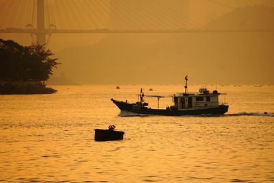 Ship sailing on sea against sky during sunset