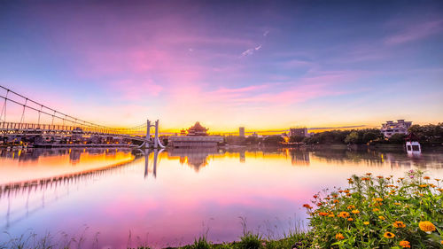 Bridge over river against sky during sunset