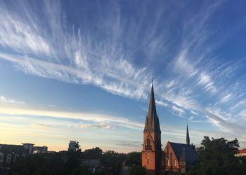 View of buildings in city against cloudy sky