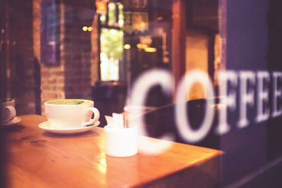 Coffee cup seen through glass window of cafe