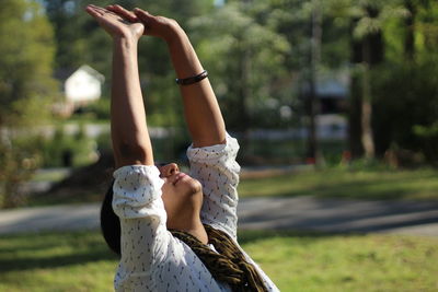 Woman exercising at park on sunny day