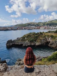 Rear view of woman looking at sea against sky