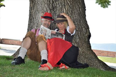 People sitting by tree trunk