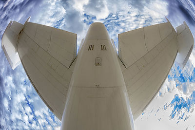 Fish-eye view of airplane flying against sky