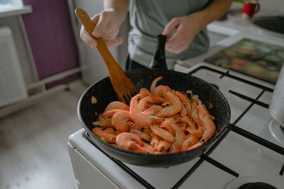 Cooking seafood, frying shrimp in a pan, homemade food