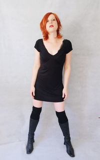 Portrait of redhead woman standing against wall