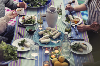 High angle view of friends sitting at dinner table in yard