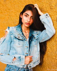 Portrait of woman standing against wall