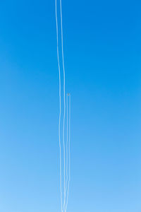 Low angle view of vapor trail against clear blue sky