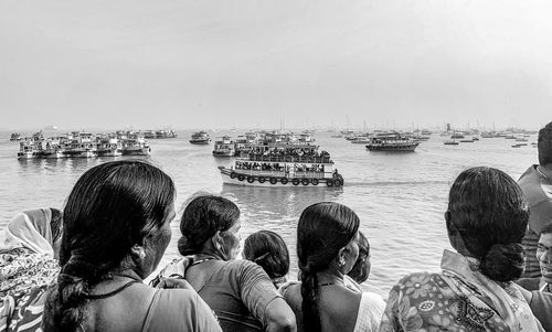 Rear view of people looking at harbor