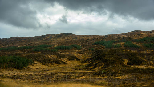 Scenic view of mountains against cloudy sky