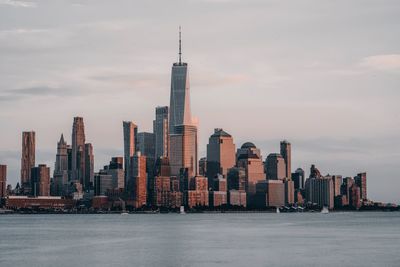 Modern buildings in city against sky during sunset