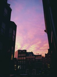 Low angle view of buildings against sky at sunset