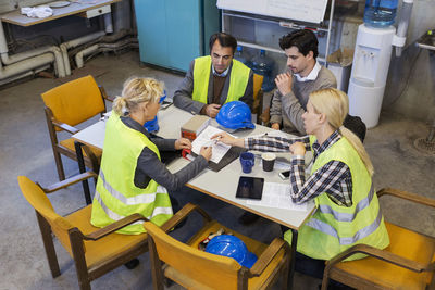 Manual workers planning at table in factory
