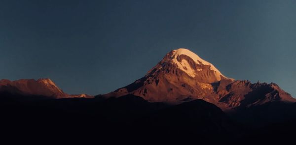 Scenic view of snowcapped mountains against clear sky