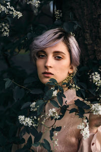 Portrait of young woman amidst plants