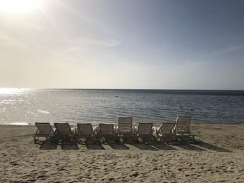 Chairs on beach against sky