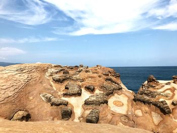 Panoramic shot of rocks on sea against sky