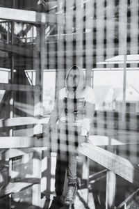 Portrait of woman standing by glass window