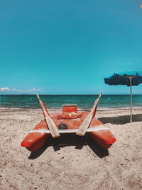 Deck chairs on beach against clear sky