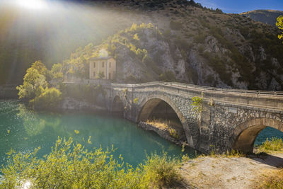 Arch bridge over river against sky