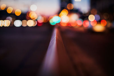 Close-up of railing against illuminated colorful lights