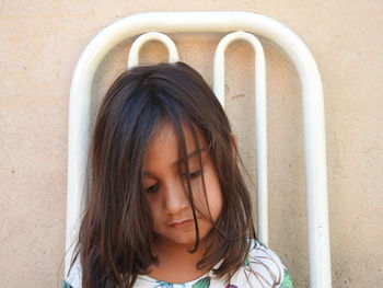 Cute girl looking down against wall