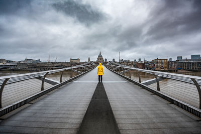 Rear view of person on london millennium footbridge leading towards st paul cathedral