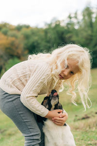 A little girl is hugging her dog.