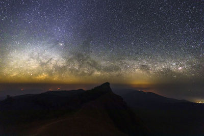 Scenic view of silhouette mountains against sky at night